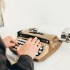 a person typing on an old fashioned typewriter