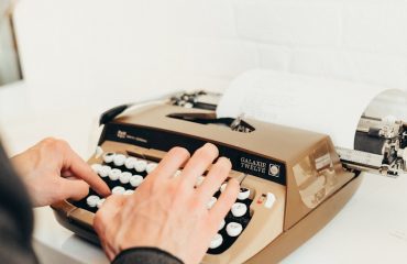 a person typing on an old fashioned typewriter